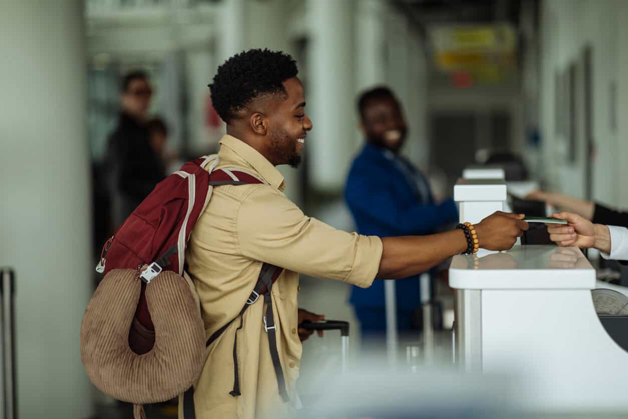 Traveler checking in at airport using credit card reward points for flights