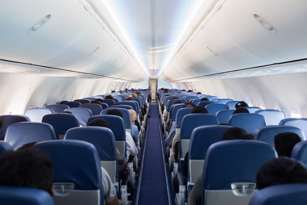 Airplane cabin with passengers seated during a full flight.