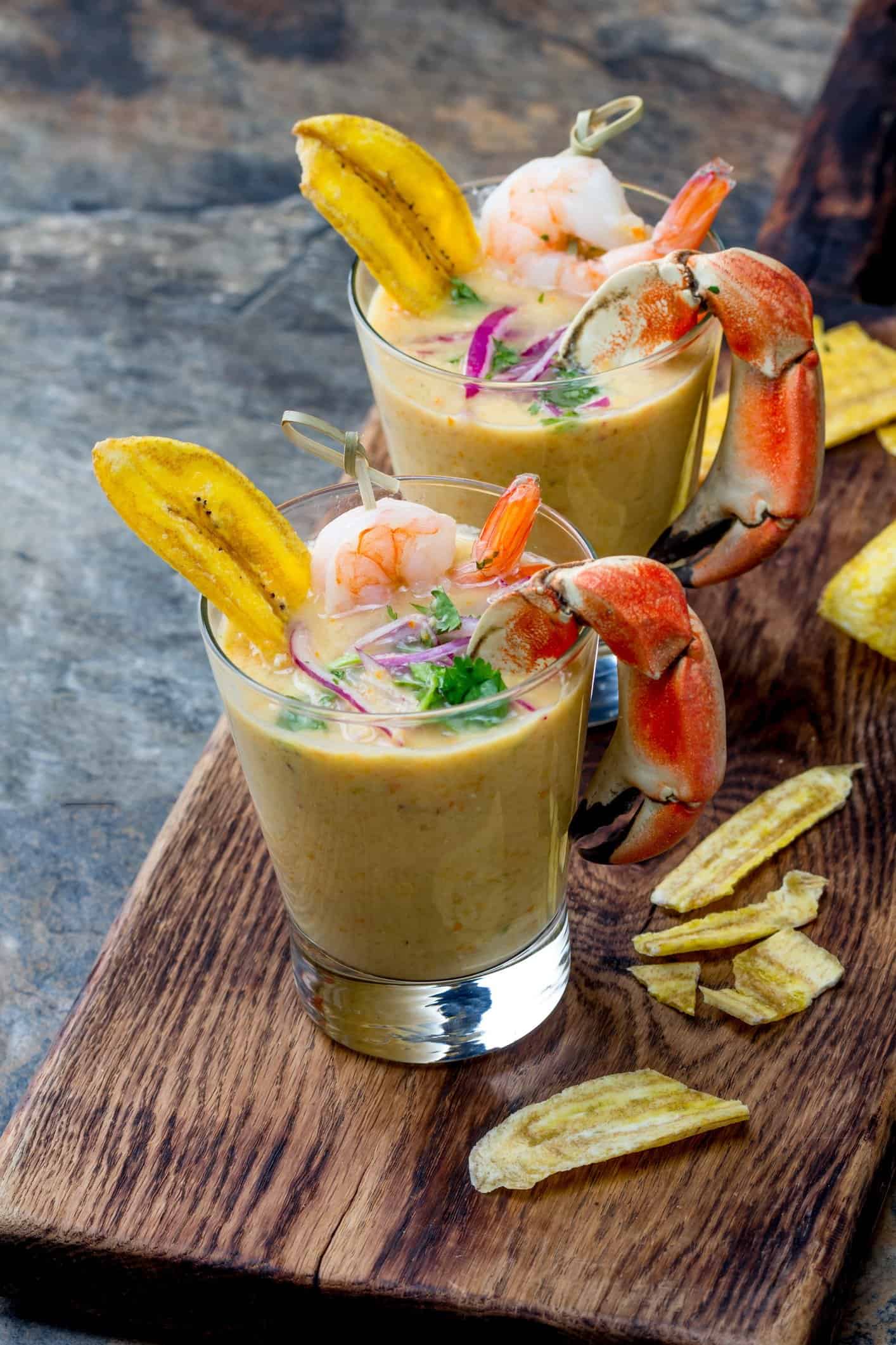 Peruvian seviche LECHE DE TIGRE. Tiger milk. Raw fish cocktail ceviche with lime, grinder, chili and cilantro. Traditional peruvian food decorated with crabs, srimps and banana chips