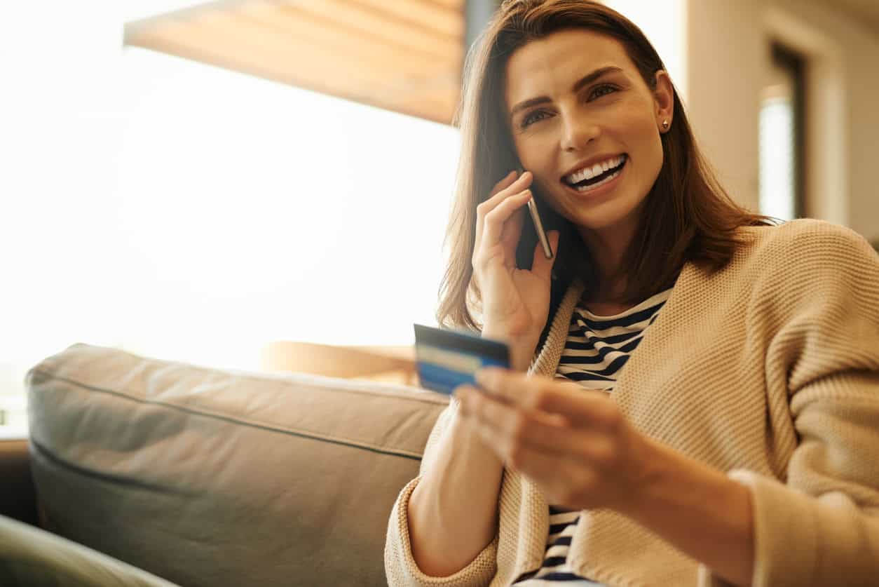 Woman calling bank evaluating their finances and card benefits.