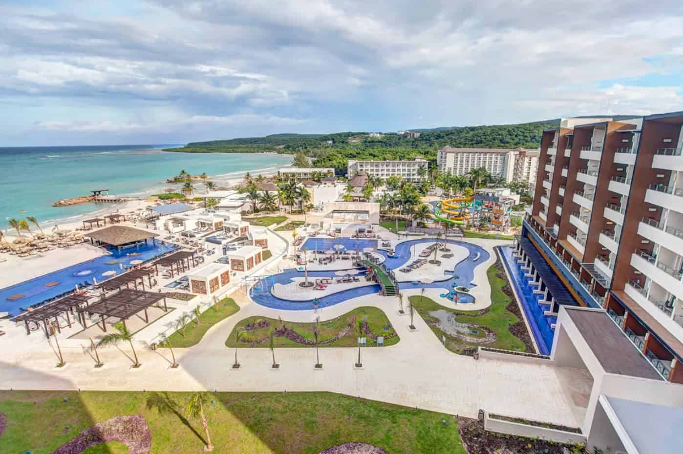 Aerial view of a beachfront all-inclusive resort with pools, water park, and Caribbean ocean coastline