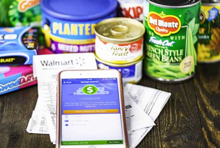 Walmart Savings Catcher app on the screen, receipts from Walmart and an assortment of groceries purchased at the store