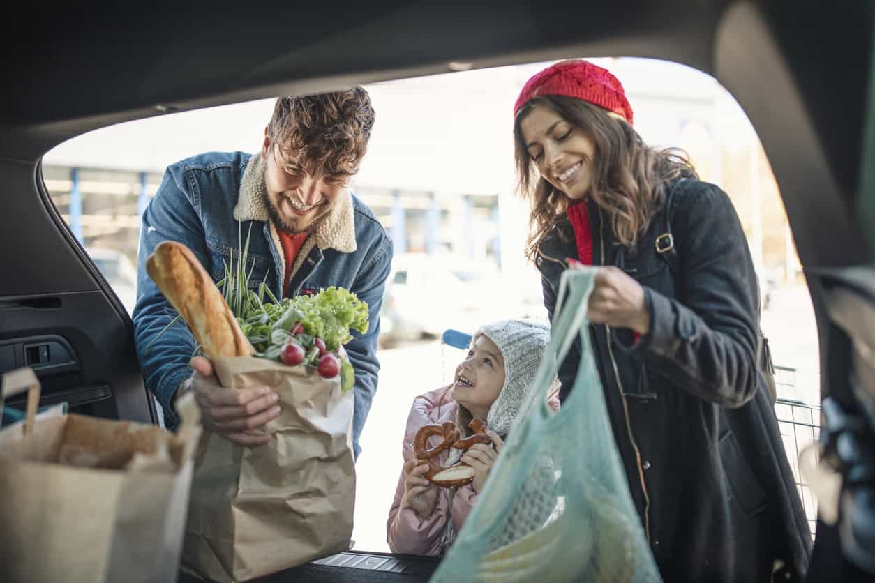 Family loading groceries in trunk