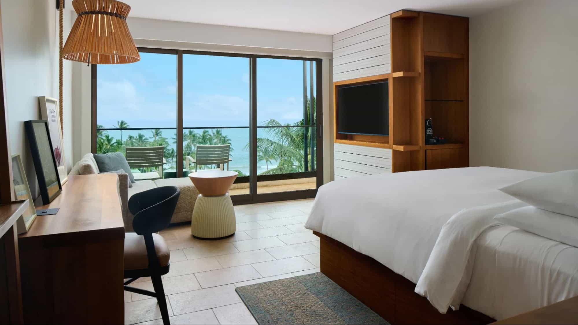 Ocean-view guest room at Andaz Maui at Wailea Resort featuring a modern king bed, private balcony, floor-to-ceiling windows, and tropical palm views