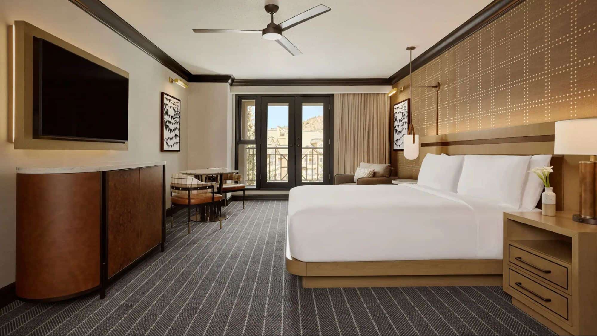 King guest room at Park Hyatt Beaver Creek Resort and Spa with modern mountain-style decor, ceiling fan, sitting area, and balcony doors overlooking the village or slopes