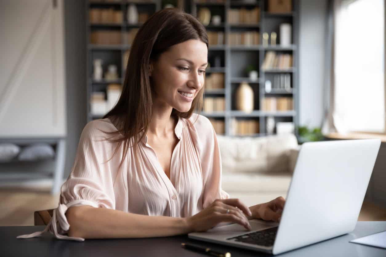 Woman researching and comparing rewards credit cards on her laptop at home.