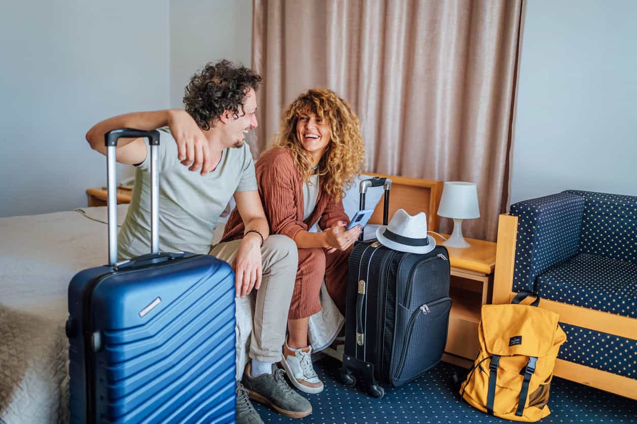Couple sitting in a hotel room with luggage