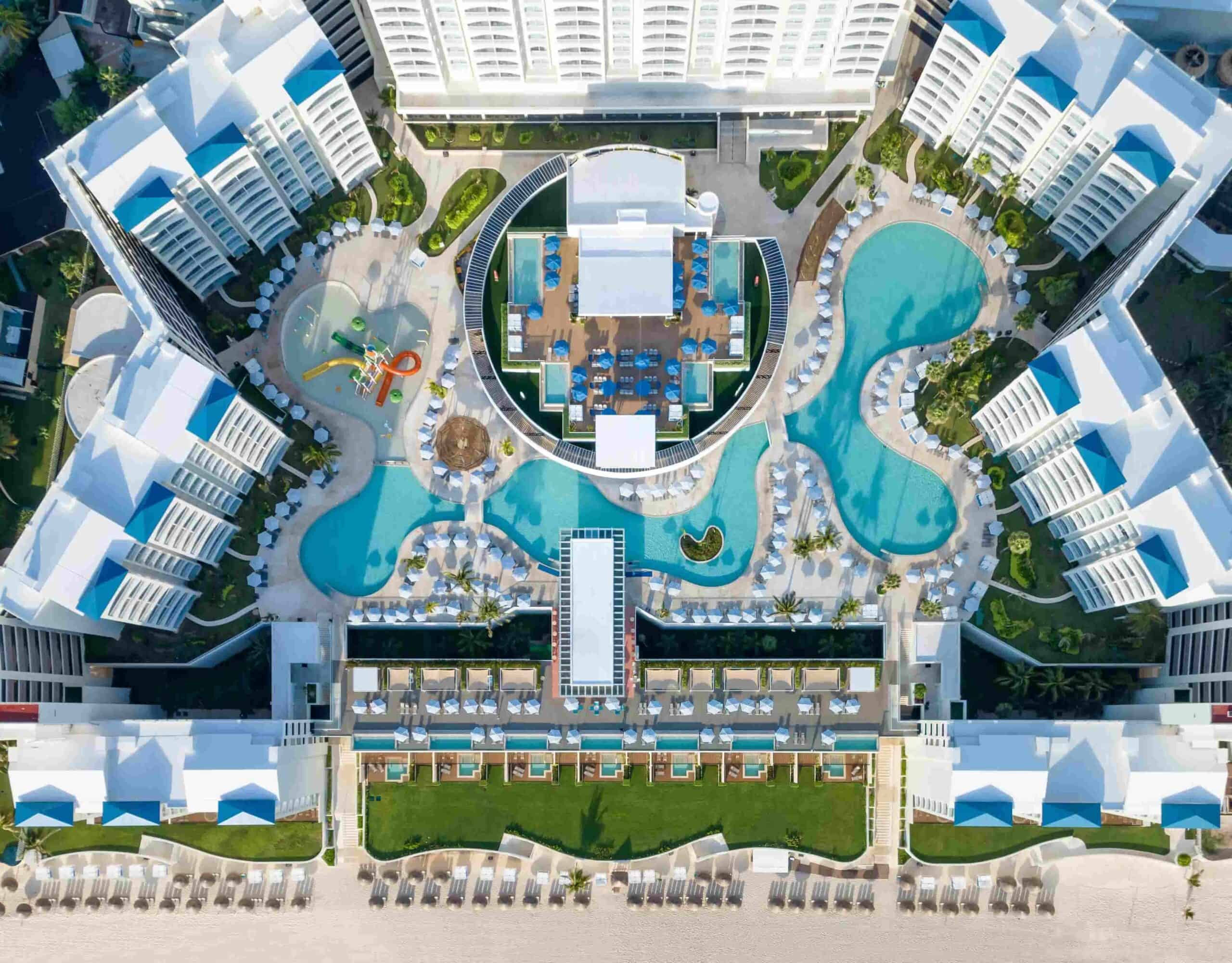 Aerial view of Hilton Cancun Mar Caribe All-Inclusive Resort showing pools, buildings, and beachfront in Cancun, Mexico