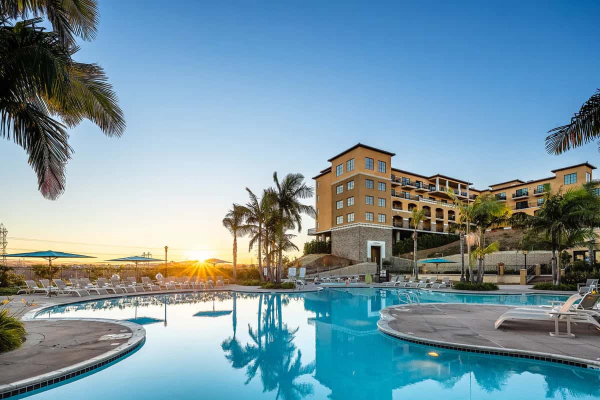 Pool at The Westin Carlsbad Resort & Spa in California at sunset with palm trees and resort buildings overlooking the water