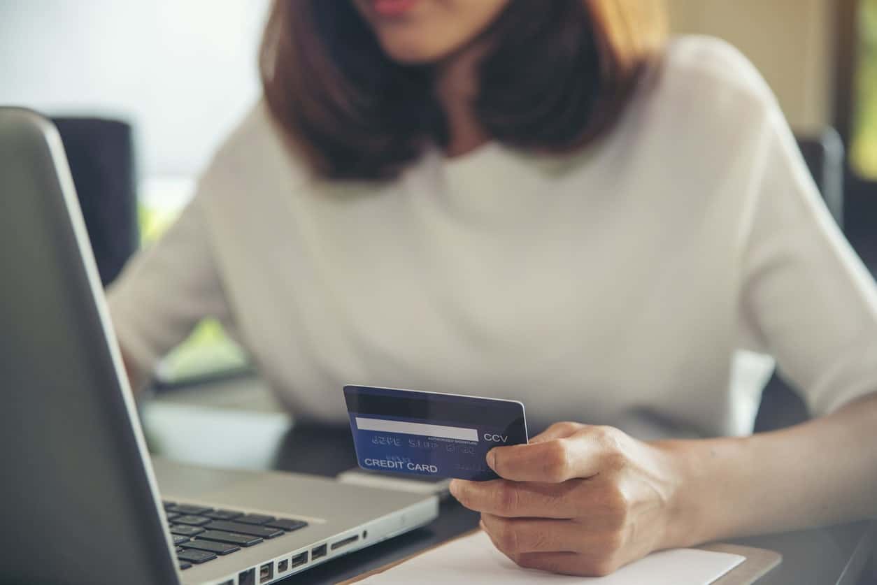 A person using a Chase Sapphire Preferred credit card to book a flight online.