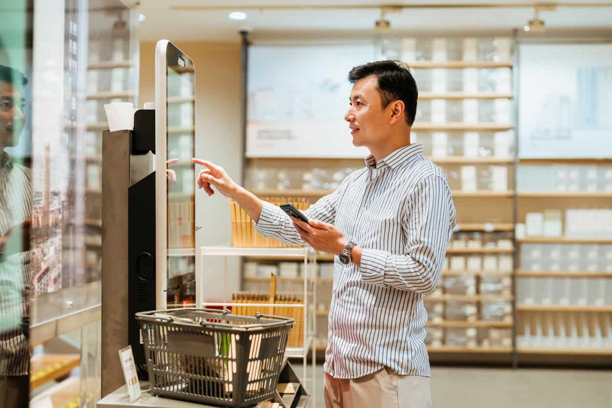 man using a self-checkout kiosk while shopping, illustrating credit card rewards and shopping perks