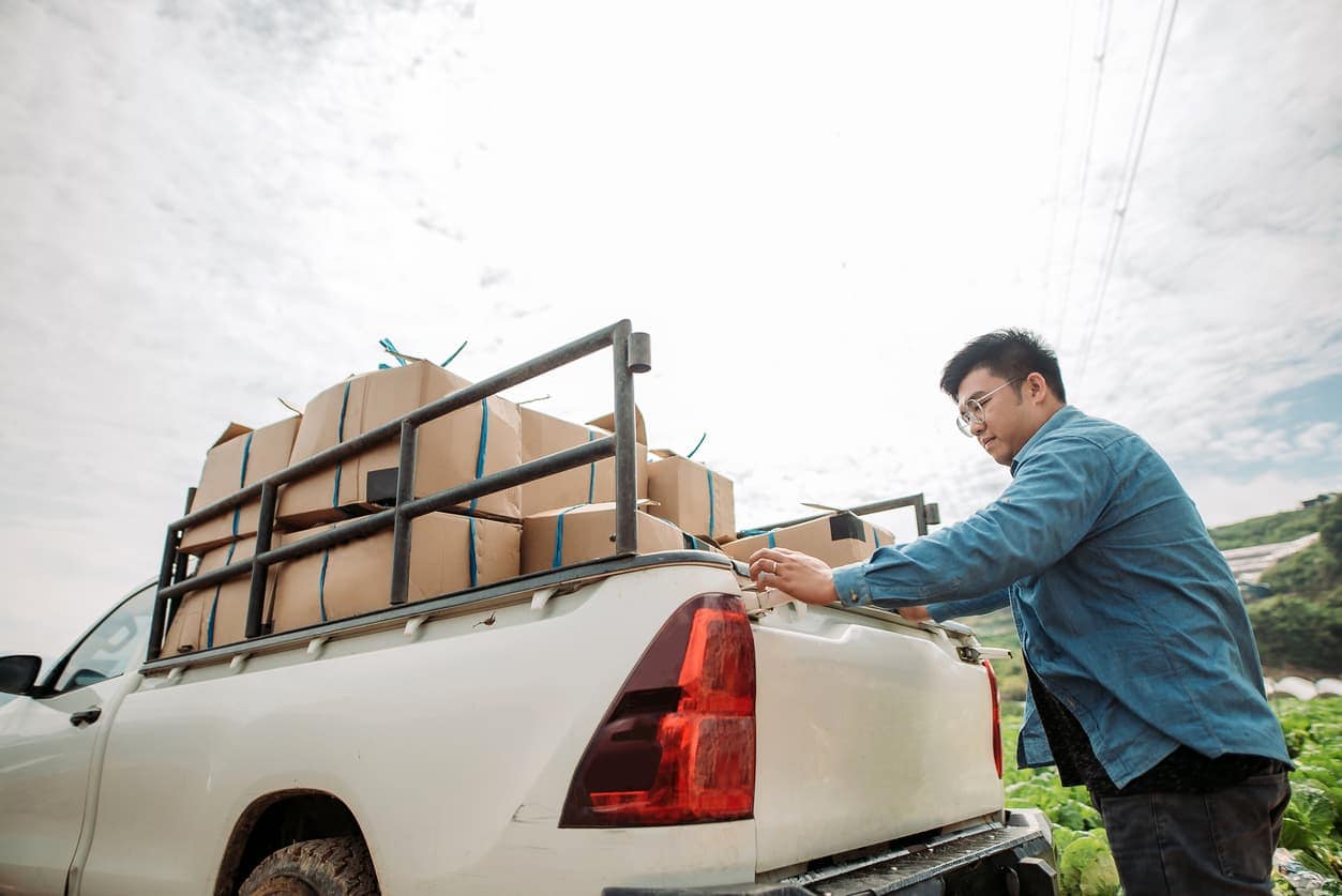 Small business owner loading boxes onto a pickup truck for delivery
