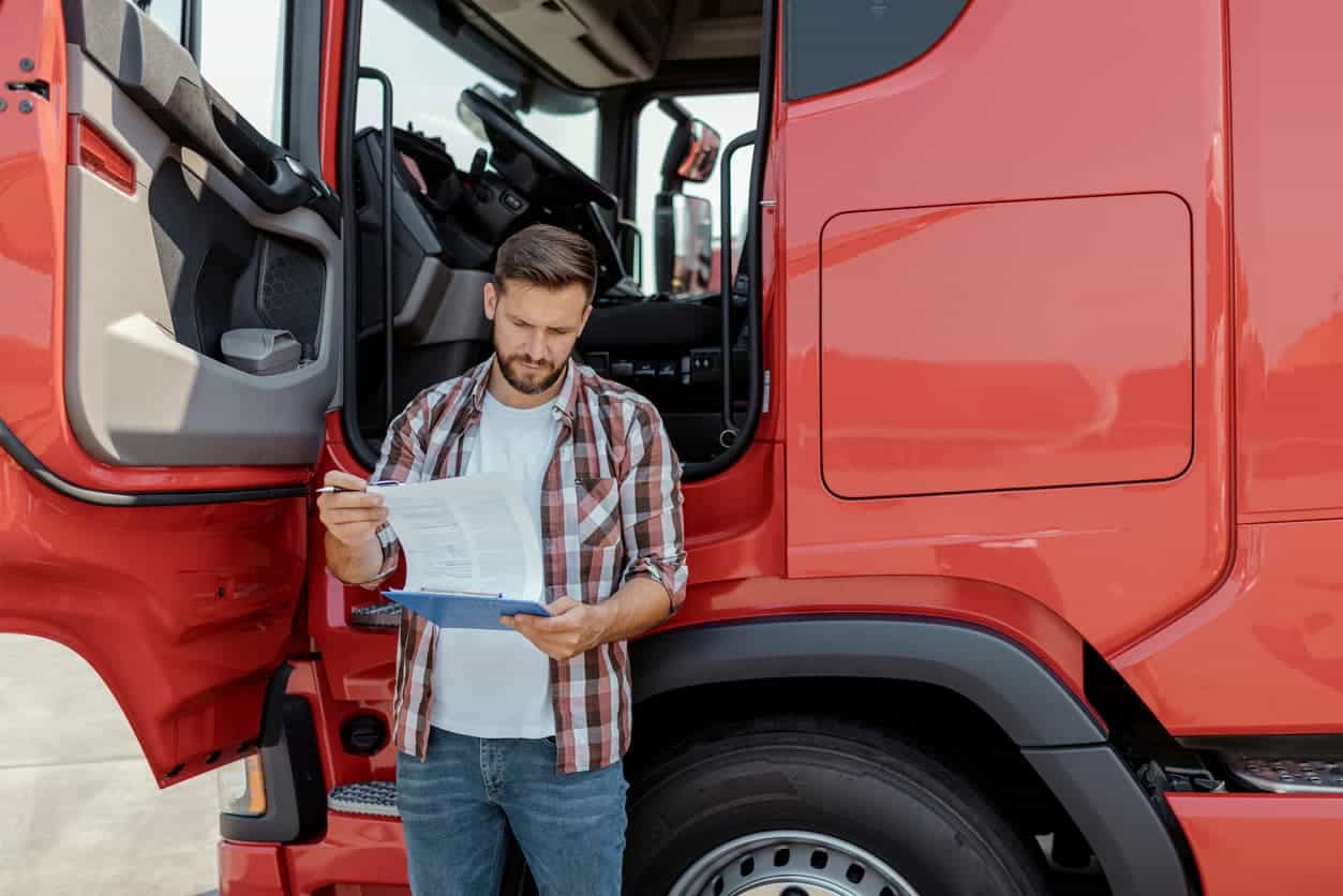 Man checking documents beside his truck