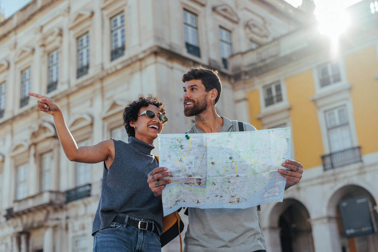 Couple exploring a city with a map, planning their trip using points and miles rewards