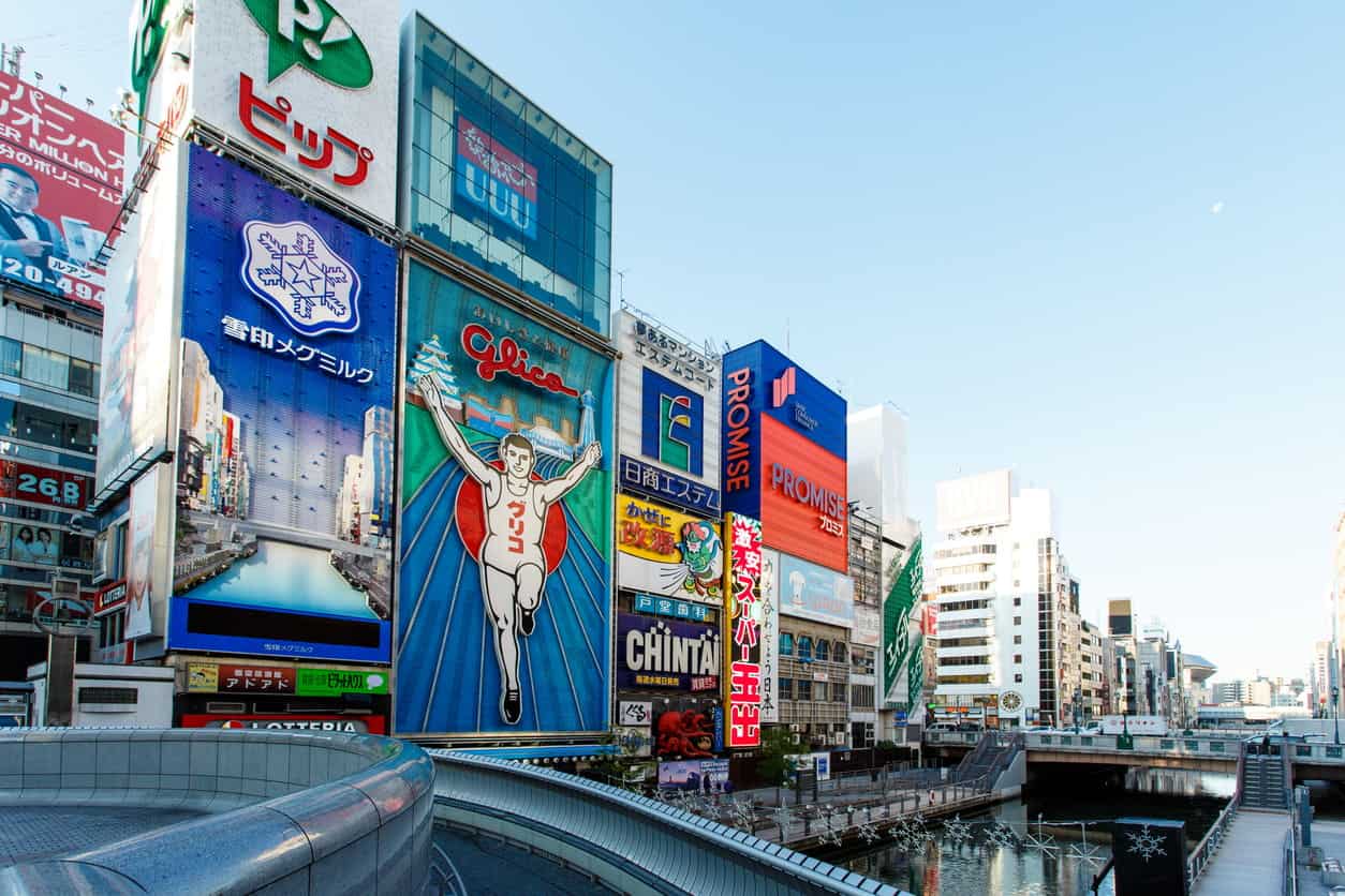Dotonbori district in Osaka, Japan with the iconic Glico sign and colorful city billboards along the canal