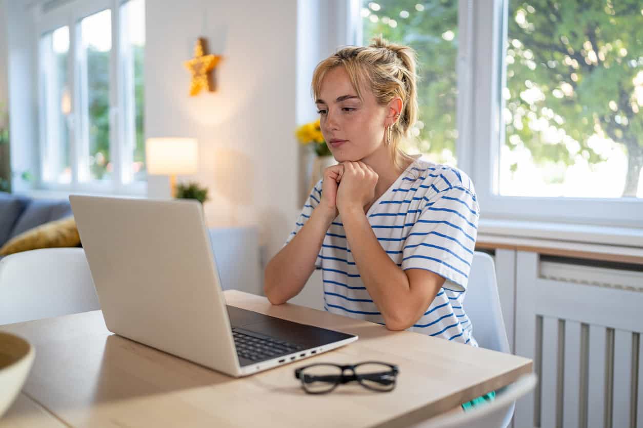 Woman reviewing flight options on an online travel booking portal using a laptop