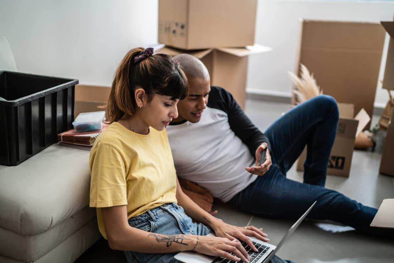 A couple using a laptop and phone to review upcoming credit card changes in 2026
