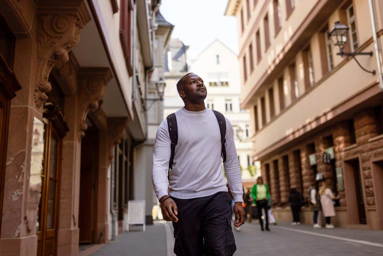 Male tourist walking through a charming European street.