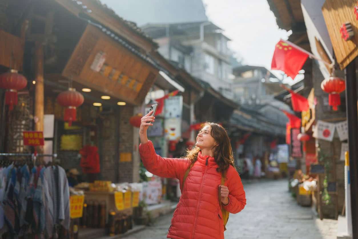 Female tourist taking a selfie in a traditional Chinese street market