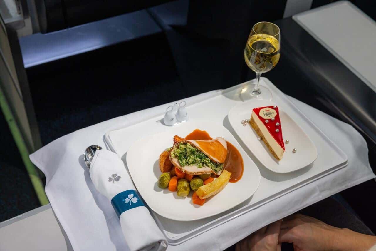 On certain business-class flights, if you prefer to settle down to sleep sooner, you can request an express tray, which includes an abridged version of the multi-course meal described above. This tray will arrive almost immediately after take off so you can maximize your sleeping time. On morning flights, business-class passengers also have their choice of several breakfast options, including smoothies, homemade granola with blueberry compote on yogurt, a bacon roll and more. For beverages, you can accompany your meal with a selection from Aer Lingus’ wine list, which includes red wine, white wine, rosé and champagne. This wine list won the Bronze medal for “Business Class Cellar” according to the 2024 Business Traveller “Cellars in the Sky” rankings. You can also get cocktails (including cosmos, margaritas, old fashioneds, negronis and more), spirits, beer, Magners Irish Cider and non-alcoholic beverages like juices, sodas, teas and coffee. Business-class passengers on all transatlantic flights will receive an amenity kit upon boarding their flight. This kit will include skincare products from Jo Browne Ireland (all of which are made using eco-friendly materials). The kit also contains a pen, a toothbrush, toothpaste, earplugs, a premium molded eye mask, luxurious socks and more. And, of course, your business-class experience will begin before you even get on the plane as all Aer Lingus business-class passengers have complimentary access to Aer Lingus Lounges in Dublin (DUB), London (LHR) and New York (JFK). Plus, if you’re flying out of or arriving in Dublin, you can check out the 51st&Green Lounge in the U.S. Pre-clearance area or the Revival Lounge located in the arrivals hall in Terminal 2. Aer Lingus Festive Food