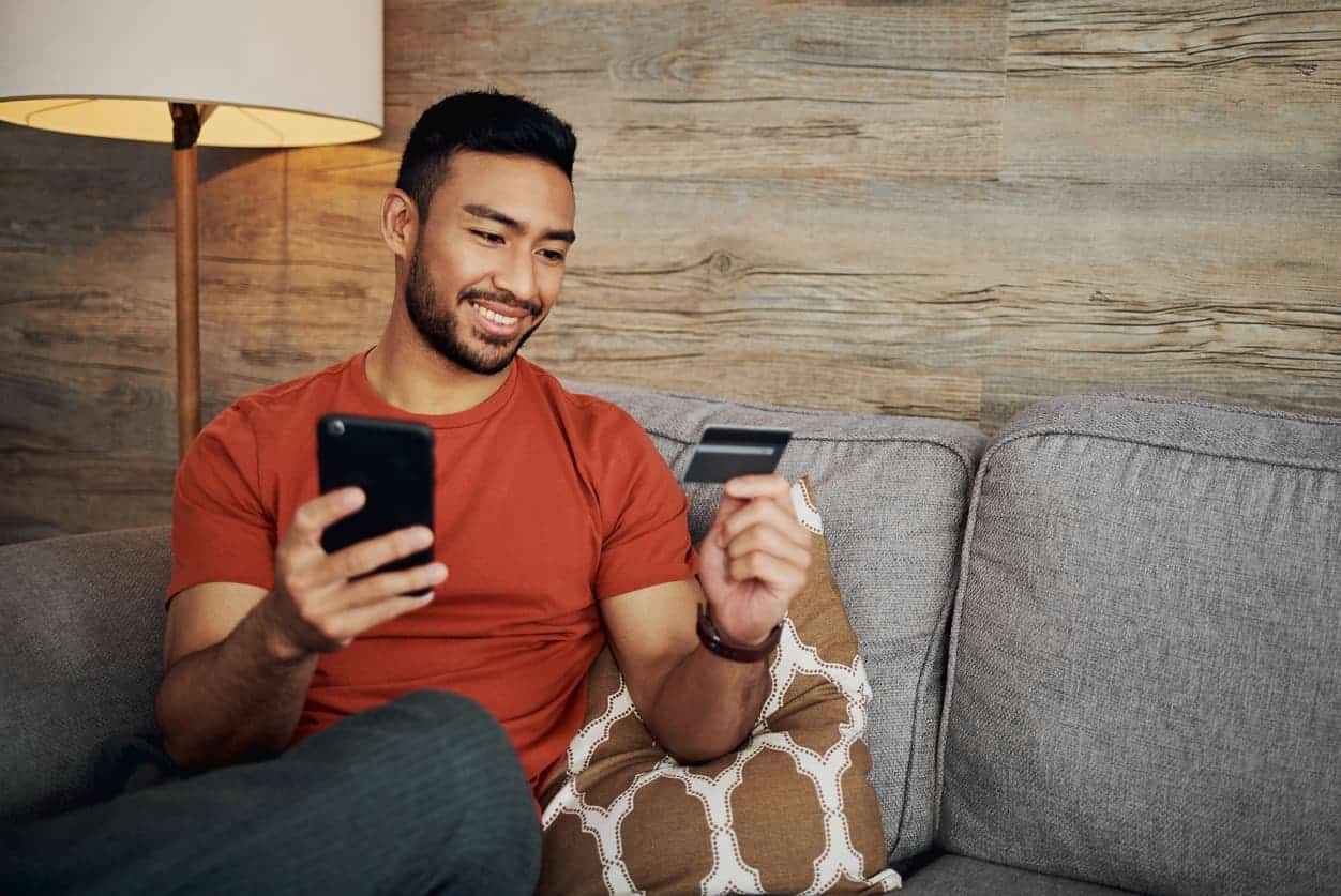 Traveler using credit card and smartphone to book Virgin Atlantic Upper Class with points and miles