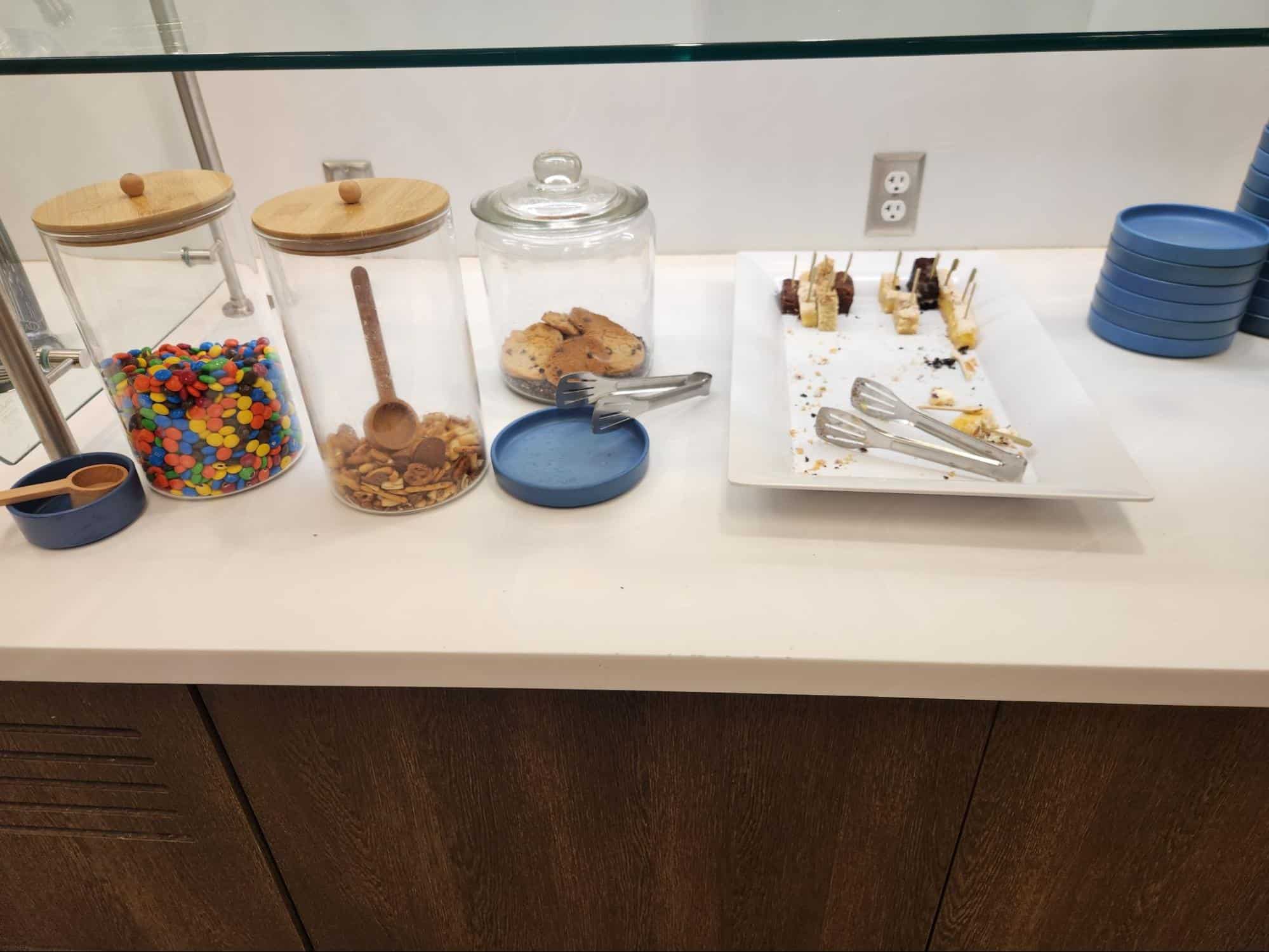candies, granola, and cookies with a few dessert bars and tongs.