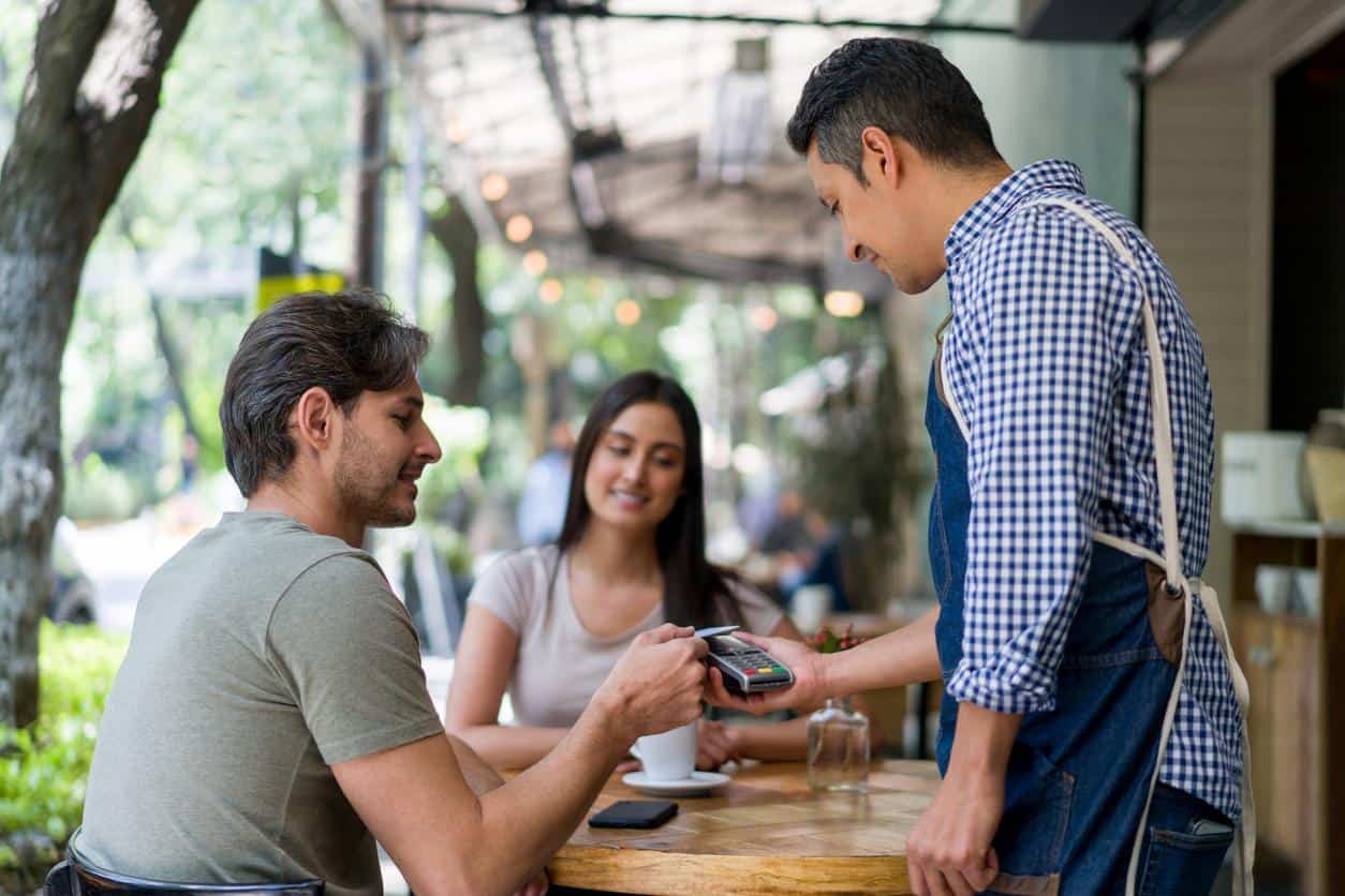 Man paying with smartphone at outdoor café