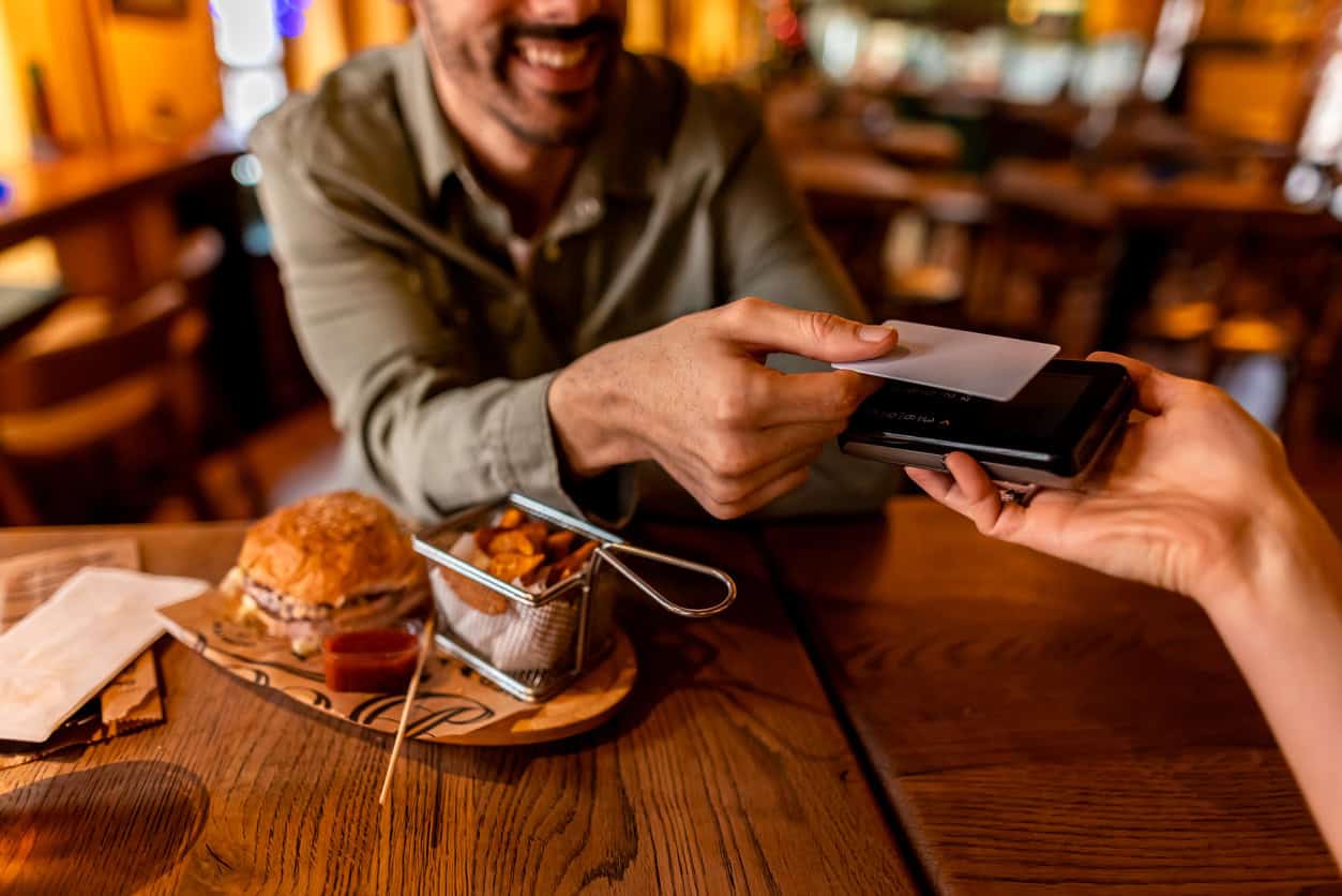 Restaurant bill and a generic card on a wooden table