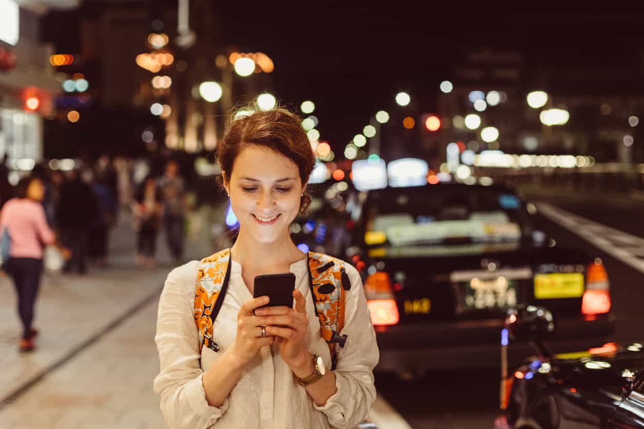 Person uses a smartphone to request a ride at night