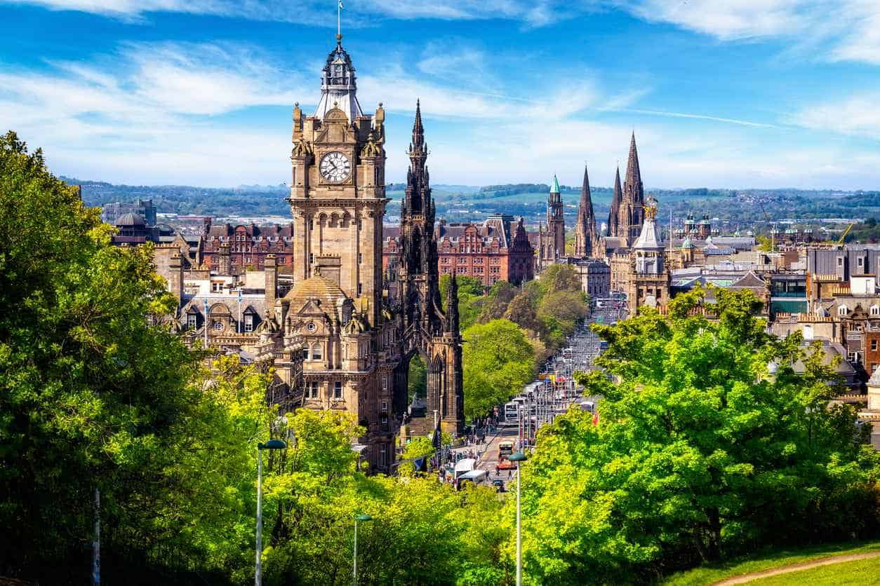Cityscape view of Edinburgh, Scotland, with historic architecture and greenery seen from Carlton Hill.