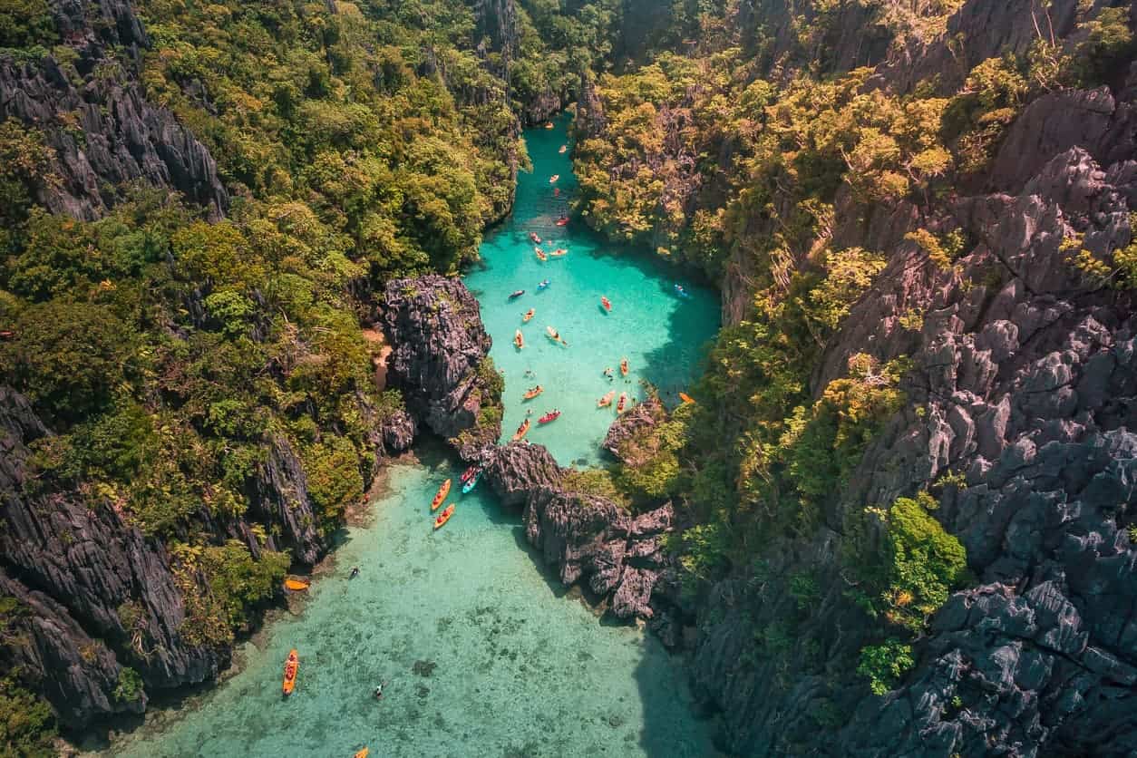 Aerial view of kayakers exploring the turquoise waters of El Nido lagoon in Palawan, Philippines