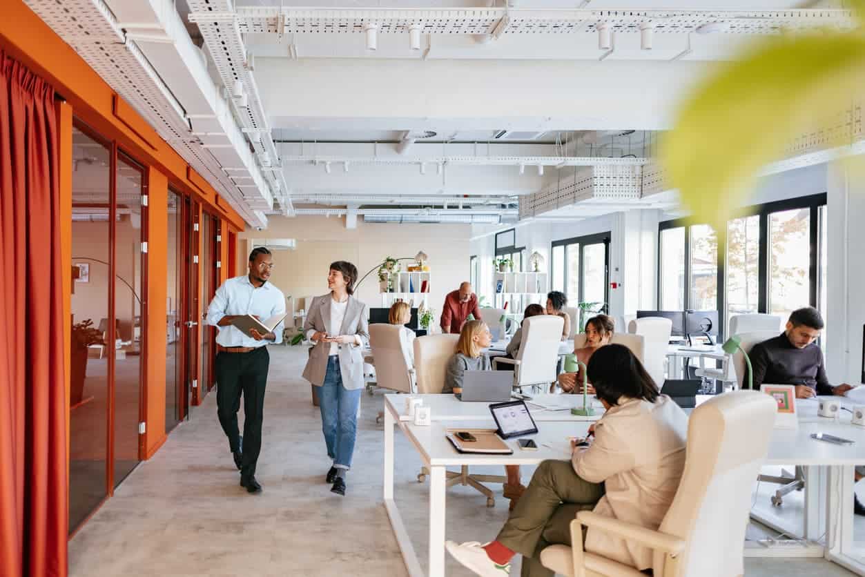 Business employees collaborating and working in a modern open-plan office environment.