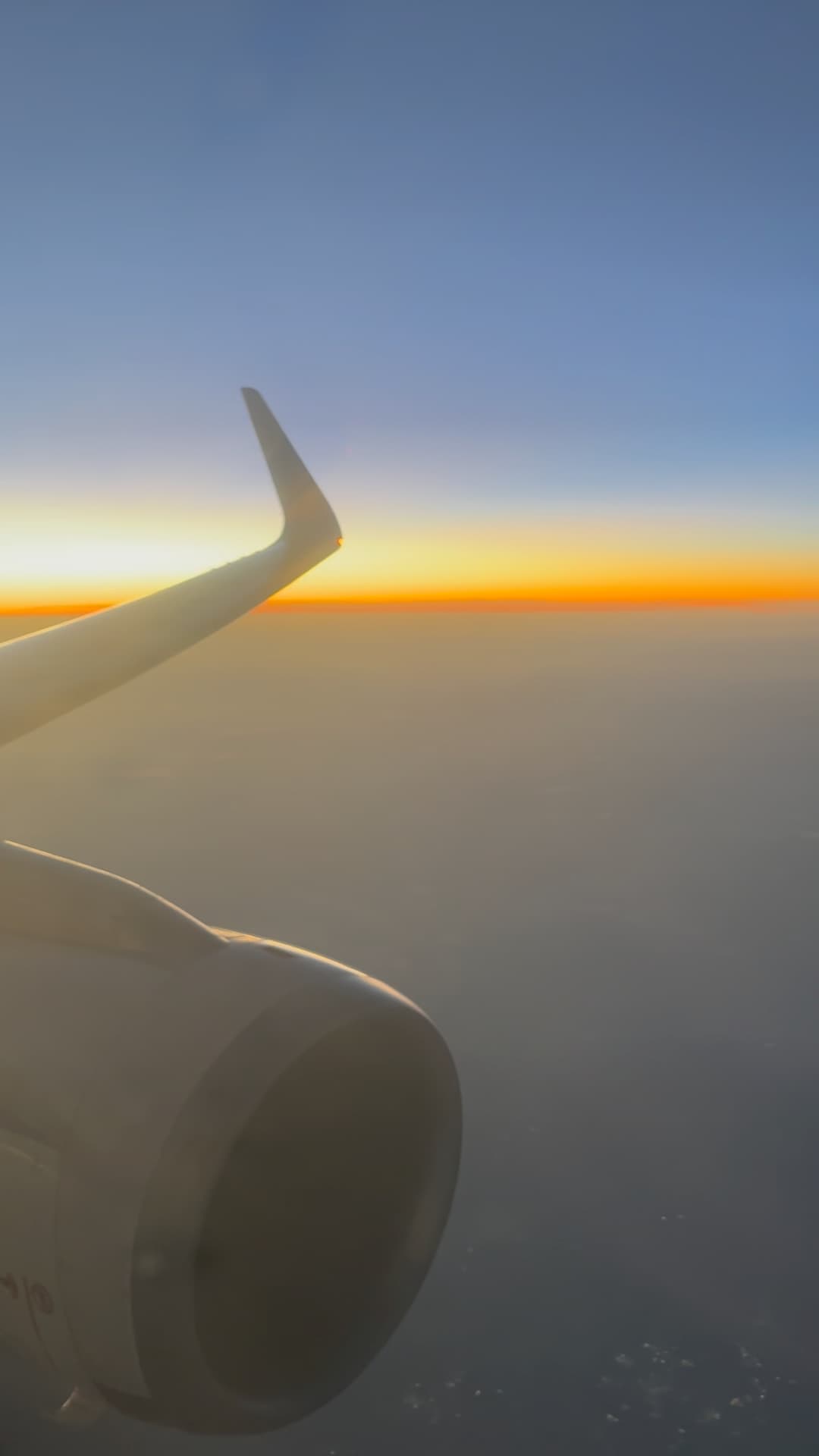 Airplane wing and engine view with a stunning sunrise above the clouds