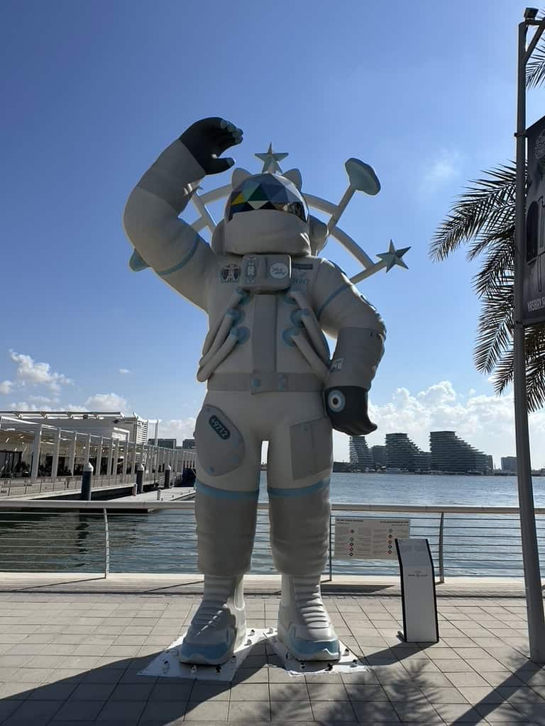Giant astronaut sculpture at Yas Bay Waterfront under clear blue sky in Abu Dhabi