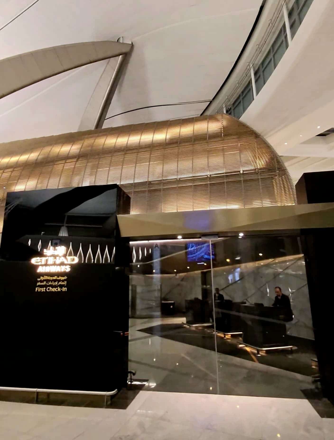 Etihad Airways First Class check-in area with modern architecture and gold lighting