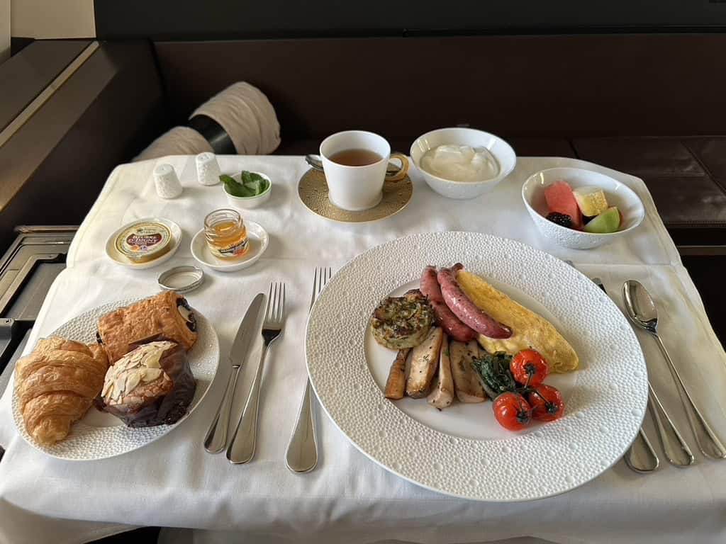 Etihad Airways First Class breakfast with omelette, pastries, fruit, and tea
