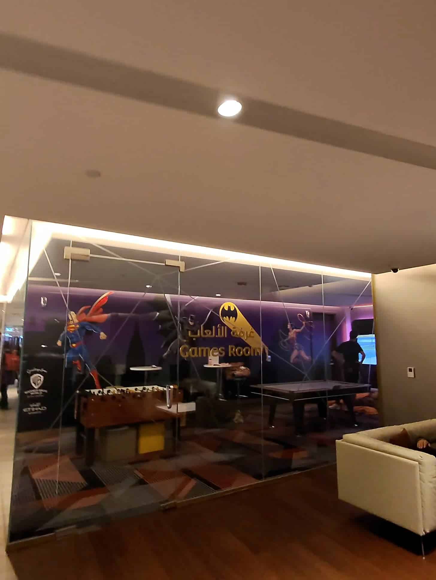 Games room featuring foosball and superhero-themed decor at Etihad Airways Lounge