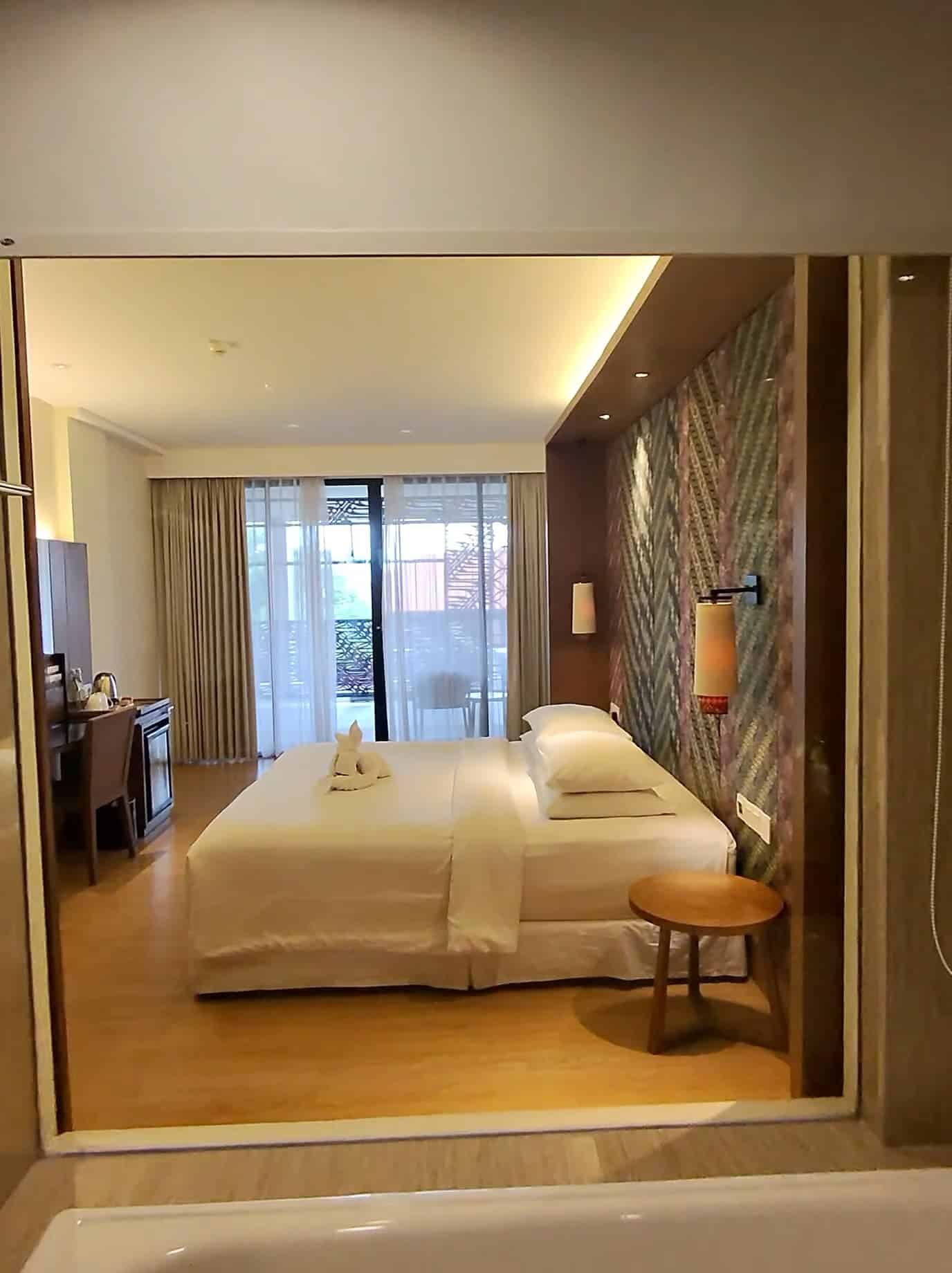 Bedroom at Four Points by Sheraton Bali with balcony and warm lighting