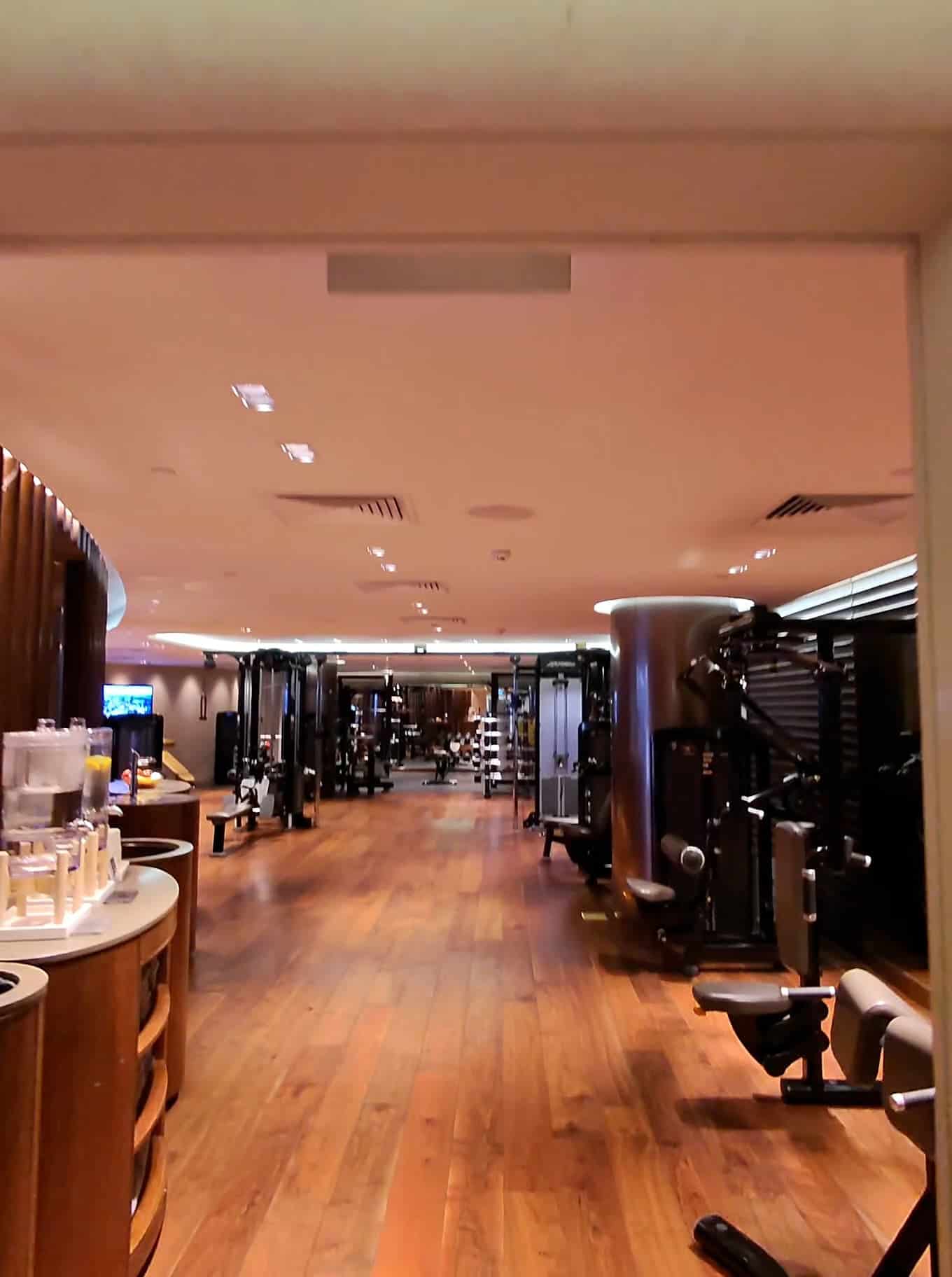 Spacious hotel fitness center with wooden flooring and modern workout equipment in Singapore