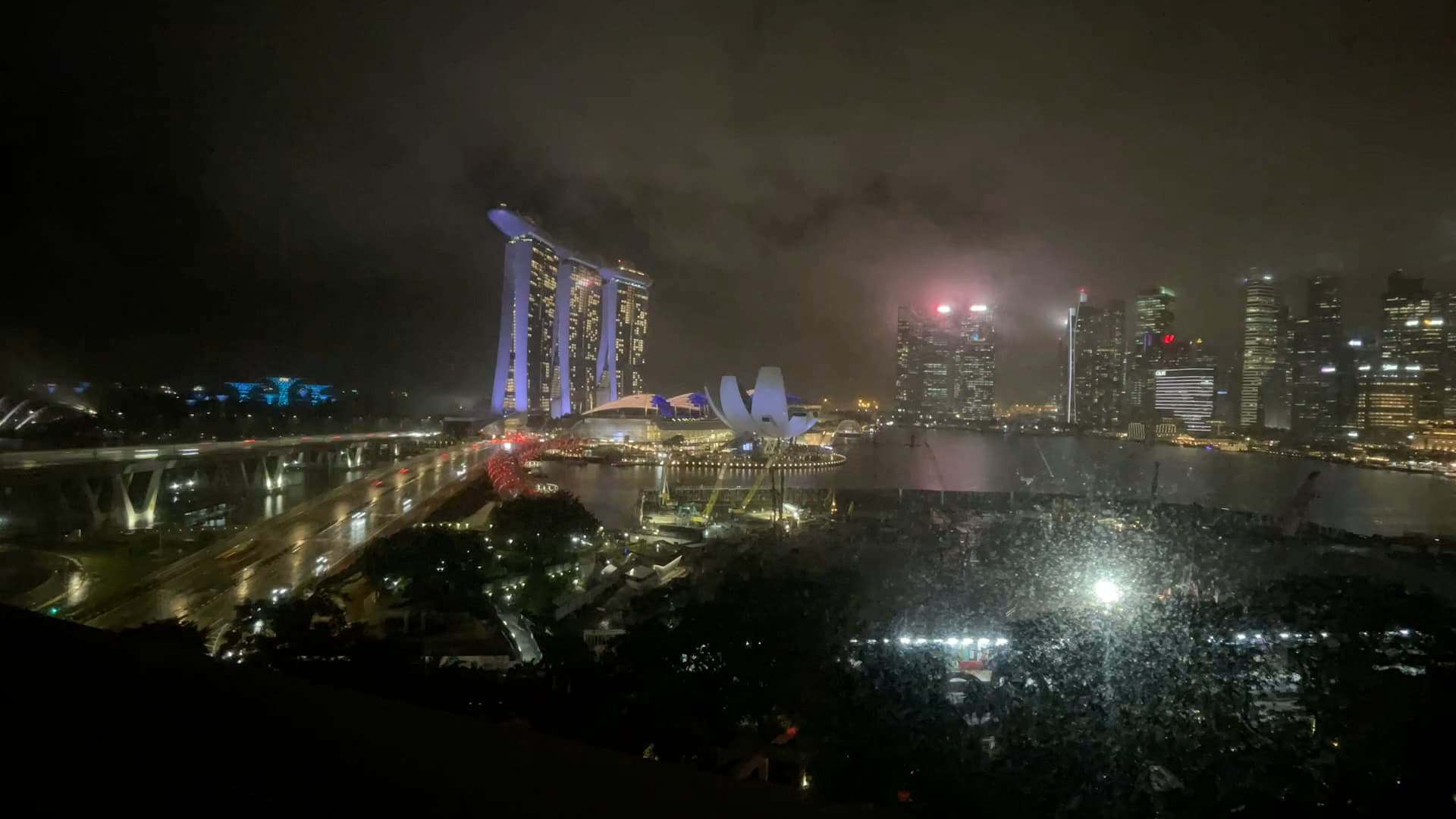 Night skyline of Marina Bay Sands and Singapore’s financial district with city lights reflecting on the water