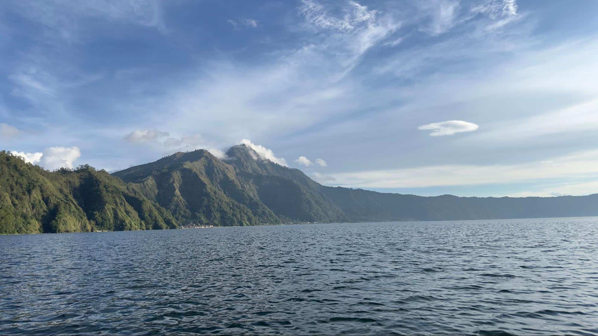 Panoramic view of Lake Batur and surrounding mountains under clear skies in Bali