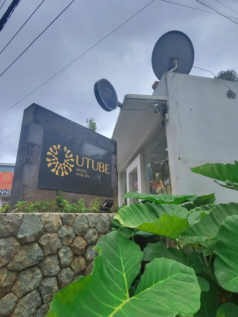 Entrance signage of Utube Hotel and Spa in Bali surrounded by tropical plants