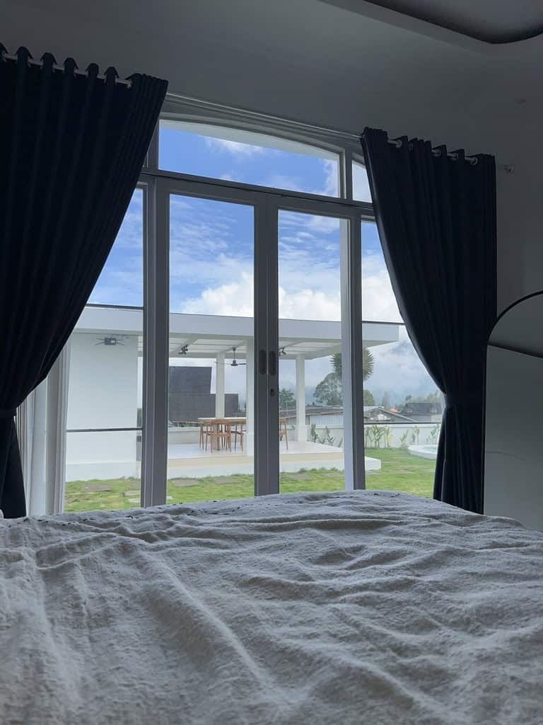 View from the bed overlooking patio and mountains at Volcano Garden View in Bali