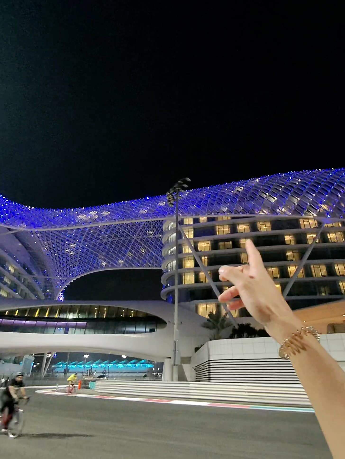 Night view of W Abu Dhabi hotel illuminated in blue lights above Yas Marina Circuit