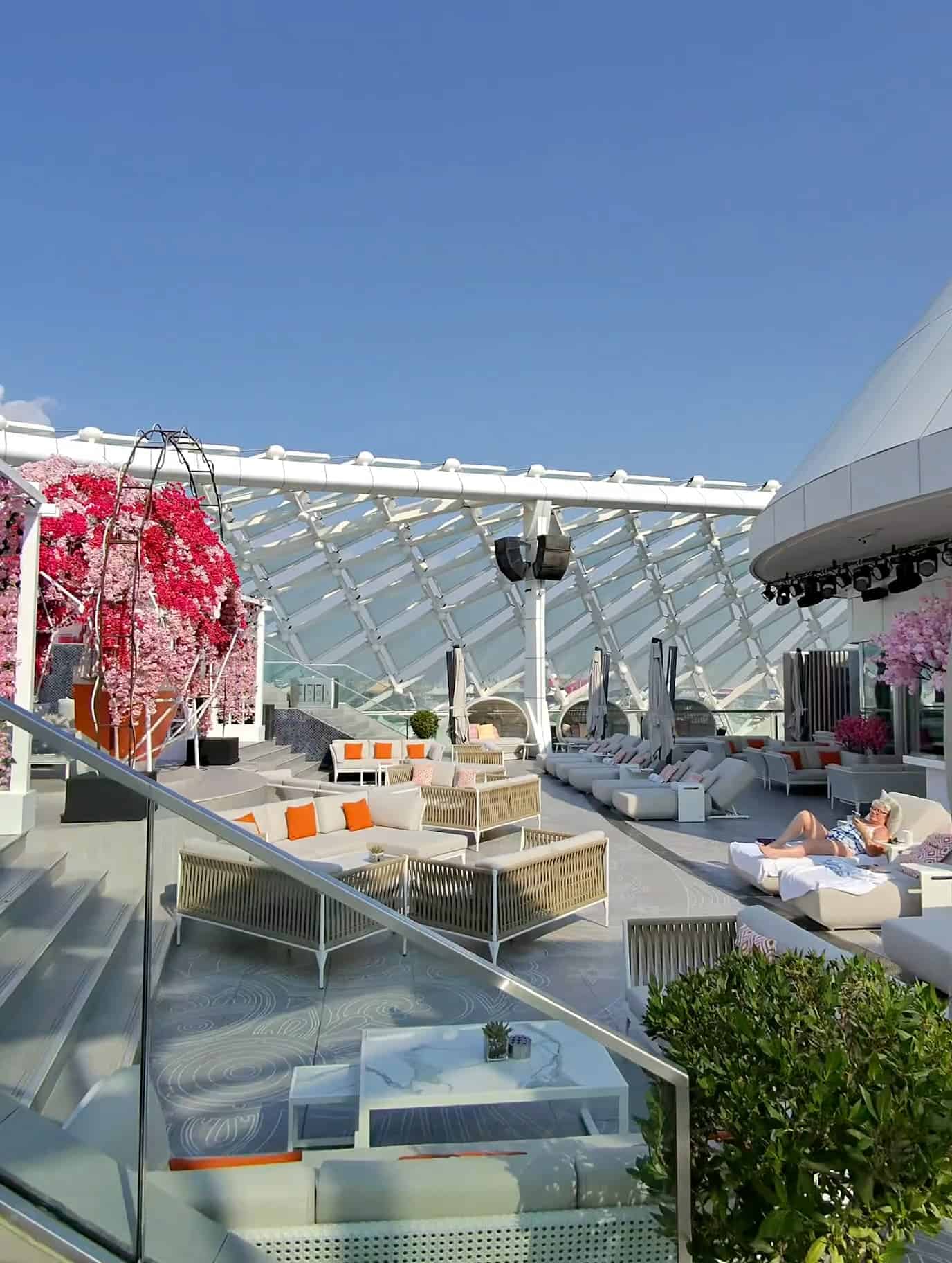 Rooftop lounge at W Abu Dhabi with modern seating and pink floral decor under clear skies