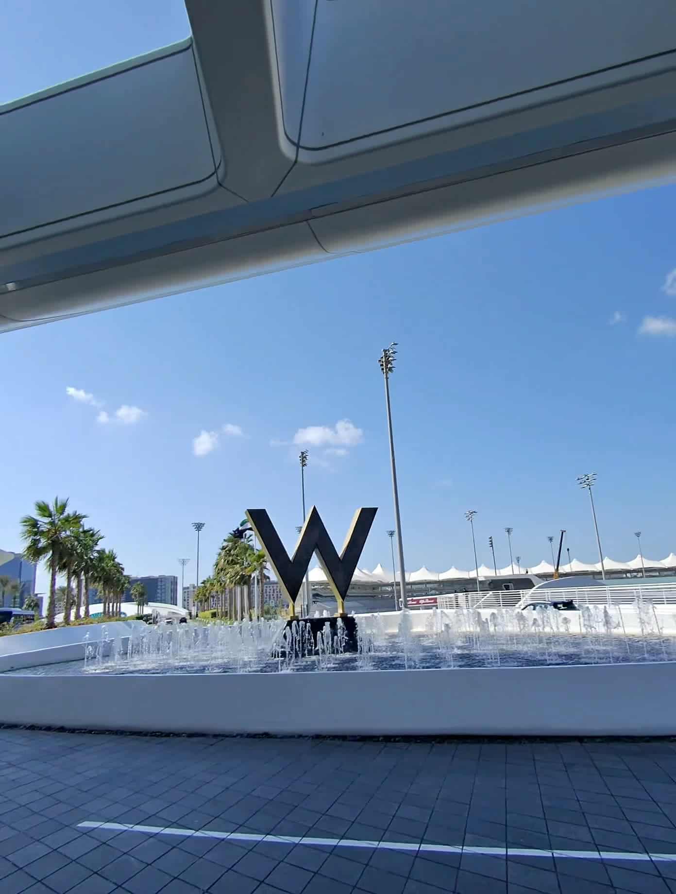 Modern W Hotel Abu Dhabi entrance with iconic W sculpture and fountain under a clear blue sky