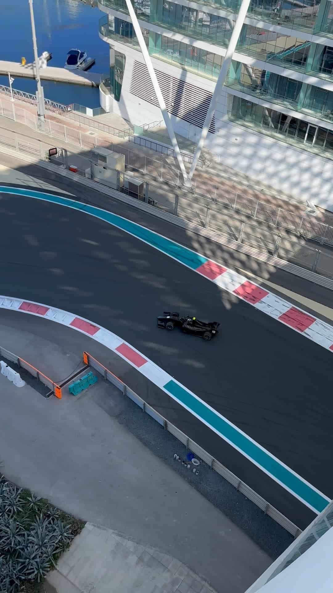 Formula car driving on the Yas Marina Circuit near W Abu Dhabi hotel