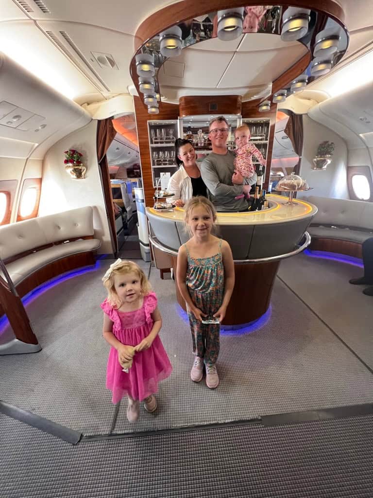 Bryce Conway and family gathered inside an airplane's onboard bar area during a flight.