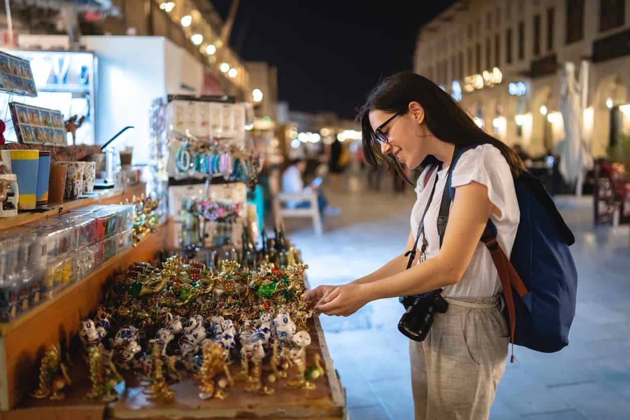 woman shopping for souvenirs at a night market in a Middle Eastern city while traveling
