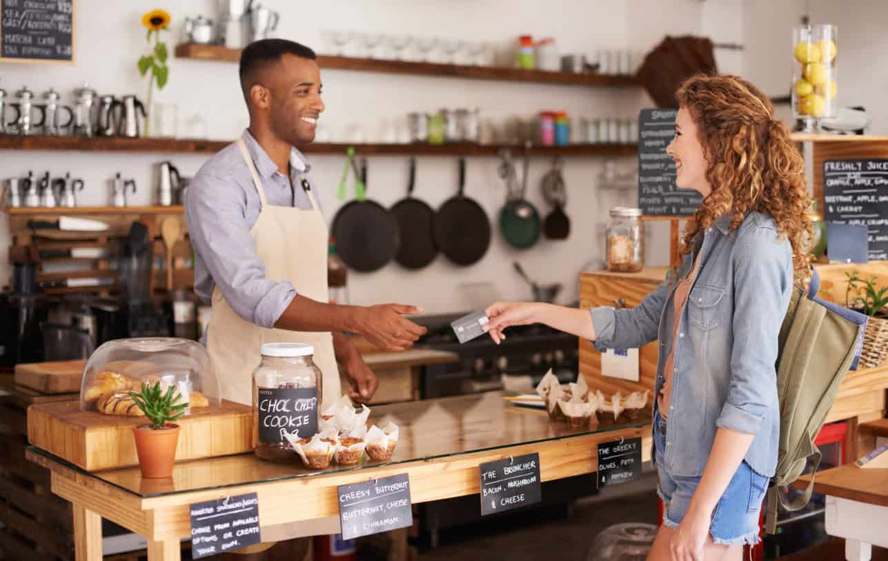 Customer paying with a card at a small business cafe counter
